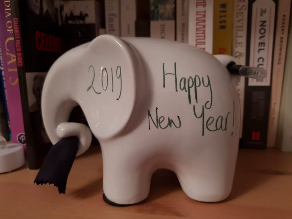 A white ceramic elephant with "2019" and "Happy New Year!" written on it